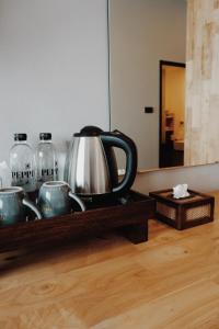チェンマイにあるPeppery Hillsの木製の棚に湯沸かし器とカップ