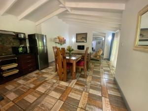 cocina y comedor con mesa y sillas en Stephna Residence, en Anse Boileau