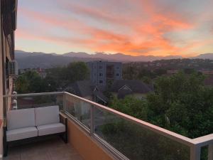 a balcony with two white chairs and a sunset at Metcalfe Luxury One bedroom Suite in Kingston