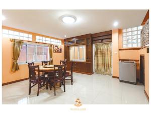 kuchnia i jadalnia ze stołem i krzesłami w obiekcie The Crystal Ranong No201 w mieście Ban Lum Than
