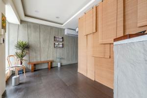 Habitación con banco y pared de madera. en 澎湖百慶旅店 l 電梯, en Magong
