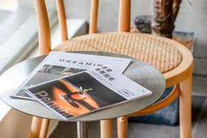 una revista sentada sobre una mesa en una silla en 澎湖百慶旅店 l 電梯, en Magong
