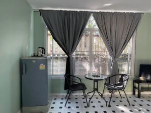 a dining room with a table and chairs and a window at เอ็มยูโฮมรีสอร์ท in Ban Khlong Lam Hin