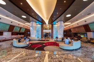 een lobby van een cruiseschip met mensen op banken bij Resort Suite 6pax Homestay at Sunway Pyramid&Sunway Lagoon in Petaling Jaya