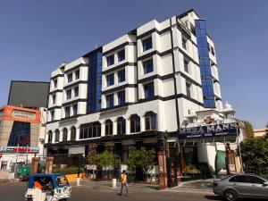 a large white building with a sign on it at Hotel Mera Mann in Lucknow