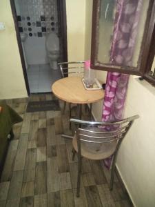 a small table and chair in a bathroom with a toilet at Goroomgo Naina Homestay Near By Landour Clock Tower Mussoorie in Mussoorie