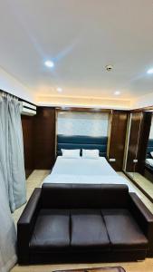 1 dormitorio con cama grande y sofá de cuero negro en Star Comfort Inn, en Lucknow