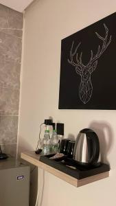 a shelf with a coffee pot and a deer picture on a wall at استديو انيق بدخول ذاتي in Riyadh