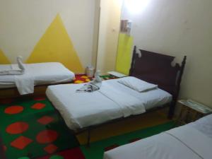 um quarto com duas camas e um verde e amarelo em Bob Marley Peace hostels luxor em Luxor