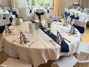 a set of tables in a room with white and blue table settings at Hotel Garni Schwane in Meßstetten