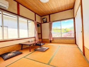 een kamer met een tafel en twee ramen bij Iriyama-So in Shimoda