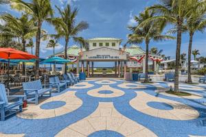 um pátio de resort com cadeiras e palmeiras em Cozy House Lauderdale By the Sea em Fort Lauderdale