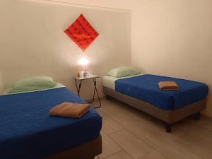 1 dormitorio con 2 camas y mesa con lámpara en Misky Wasi en San Pedro de Atacama
