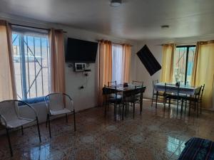 ein Wohnzimmer mit Tisch und Stühlen und einem Fernseher in der Unterkunft Misky Wasi in San Pedro de Atacama