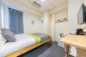 sypialnia z łóżkiem z oknem i biurkiem w obiekcie JA Hotel Bentencho 弁天町 w Osace