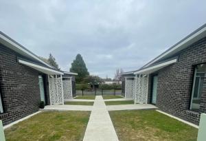 a walkway between two brick buildings at Four Square Short Stay Accommodation Railton in Railton