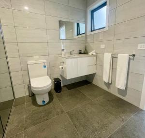 a bathroom with a toilet and a sink and a mirror at Four Square Short Stay Accommodation Railton in Railton