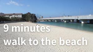 eine Brücke über einen Fluss mit der Aufschrift „Minuten zu Fuß zum Strand“ in der Unterkunft Smile Hotel Naha City Resort in Naha
