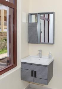 ein Bad mit einem Waschbecken und einem Spiegel in der Unterkunft Hosted by Noel in Naivasha