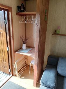 a small room with a couch and a shelf at Domki WIKA 2 in Ustka