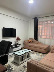 a living room with a couch and a flat screen tv at Silva-Mindvalley in Nakuru
