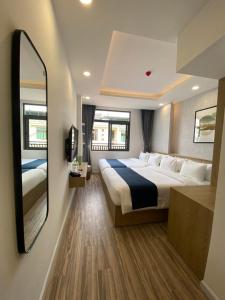 - une chambre avec un grand lit et un grand miroir dans l'établissement Phương Mai Hotel Đà Lạt, à Đà Lạt