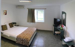 a hotel room with a bed and a television at Hanul Piratilor Camping Village in Mamaia Nord