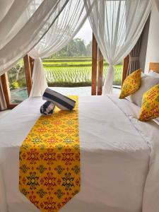 a bed with a remote control on top of it at The Alus Cottage and Villa in Ubud
