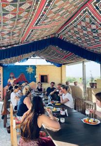 kings villa Jaisalmer في جيلسامر: مجموعة من الناس يجلسون على طاولة يأكلون الطعام