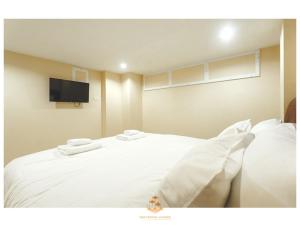 sypialnia z białym łóżkiem i telewizorem z płaskim ekranem w obiekcie The Crystal Ranong No202 w mieście Ban Lum Than