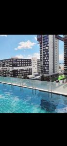 a large swimming pool with buildings in the background at Habitación 416 Sonata in Lomas de Angelopolis