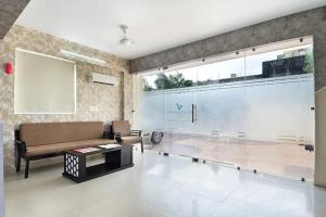 salon z kanapą i dużym oknem w obiekcie the indigo premium w mieście Noida