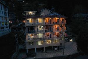 apartamentowiec w nocy z włączonymi światłami w obiekcie Nirvana -A Balcony Rooms Hotel-A True View Of Mountains w mieście Manāli