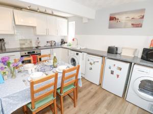 a kitchen with a table and chairs and a sink at Willow Cottage in Ventnor