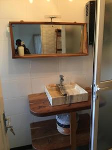 een badkamer met een wastafel en een spiegel bij la villa sur la plage in Palmarin