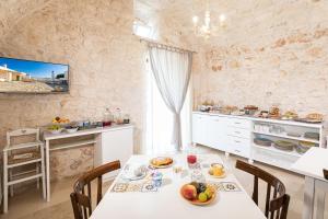 eine Küche mit einem Tisch und Stühlen im Zimmer in der Unterkunft Masseria Abadia Uno in Ostuni