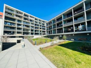 an apartment building with a lawn in front of it at APSTAY Serviced Apartments - City Center - FREE Parking - Self Check-in in Graz