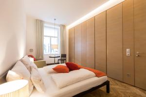 ein Wohnzimmer mit einer weißen Couch mit Kissen darauf in der Unterkunft Hollmann Beletage Design & Boutique Hotel in Wien