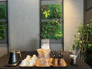 a table with tea cups and pitchers and a vertical garden at HOTEL SUI AKASAKA by ABEST in Tokyo