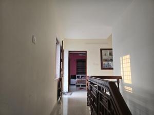 un corridoio di una casa con scala e soggiorno di Geetha Ravi Nilayam a Palakkad