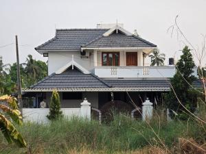 una casa bianca con tetto nero di Geetha Ravi Nilayam a Palakkad