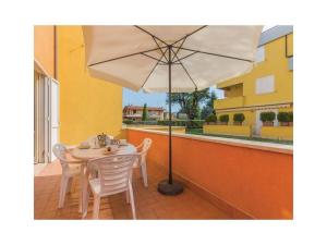 d'une table, de chaises et d'un parasol sur le balcon. dans l'établissement Garden Ville Comfortable holiday residence, à Sirmione