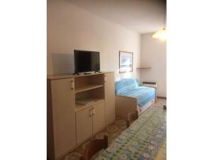 - une petite chambre avec un lit et une télévision dans l'établissement Garden Ville Comfortable holiday residence, à Sirmione