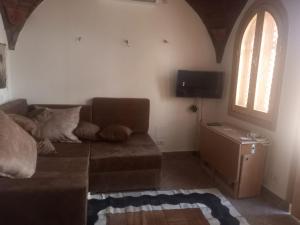 a living room with a couch and a window at Guesthouse Nut in Luxor