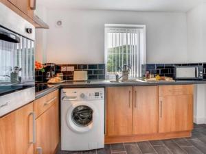 eine Küche mit einer Waschmaschine und einem Waschbecken in der Unterkunft Sunset View Apartment in Skinningrove by Bevilla in Skinningrove