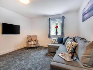 ein Wohnzimmer mit einem Sofa und einem TV in der Unterkunft Sunset View Apartment in Skinningrove by Bevilla in Skinningrove