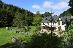 Ein weißes Haus auf einem Feld mit einem Zaun in der Unterkunft Ferienhaus Schmelzmühle in Prosterath