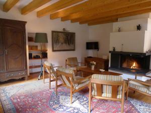 ein Wohnzimmer mit einem Tisch, Stühlen und einem Kamin in der Unterkunft Ferienhaus Schmelzmühle in Prosterath