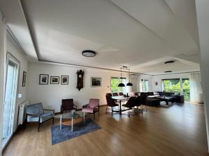 ein Wohnzimmer mit Stühlen und Tischen in einem Zimmer in der Unterkunft Hillside Villa in Sarajevo