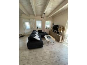 ein Wohnzimmer mit einem schwarzen Sofa und einem Tisch in der Unterkunft Alma Comfortable holiday residence in Haselünne